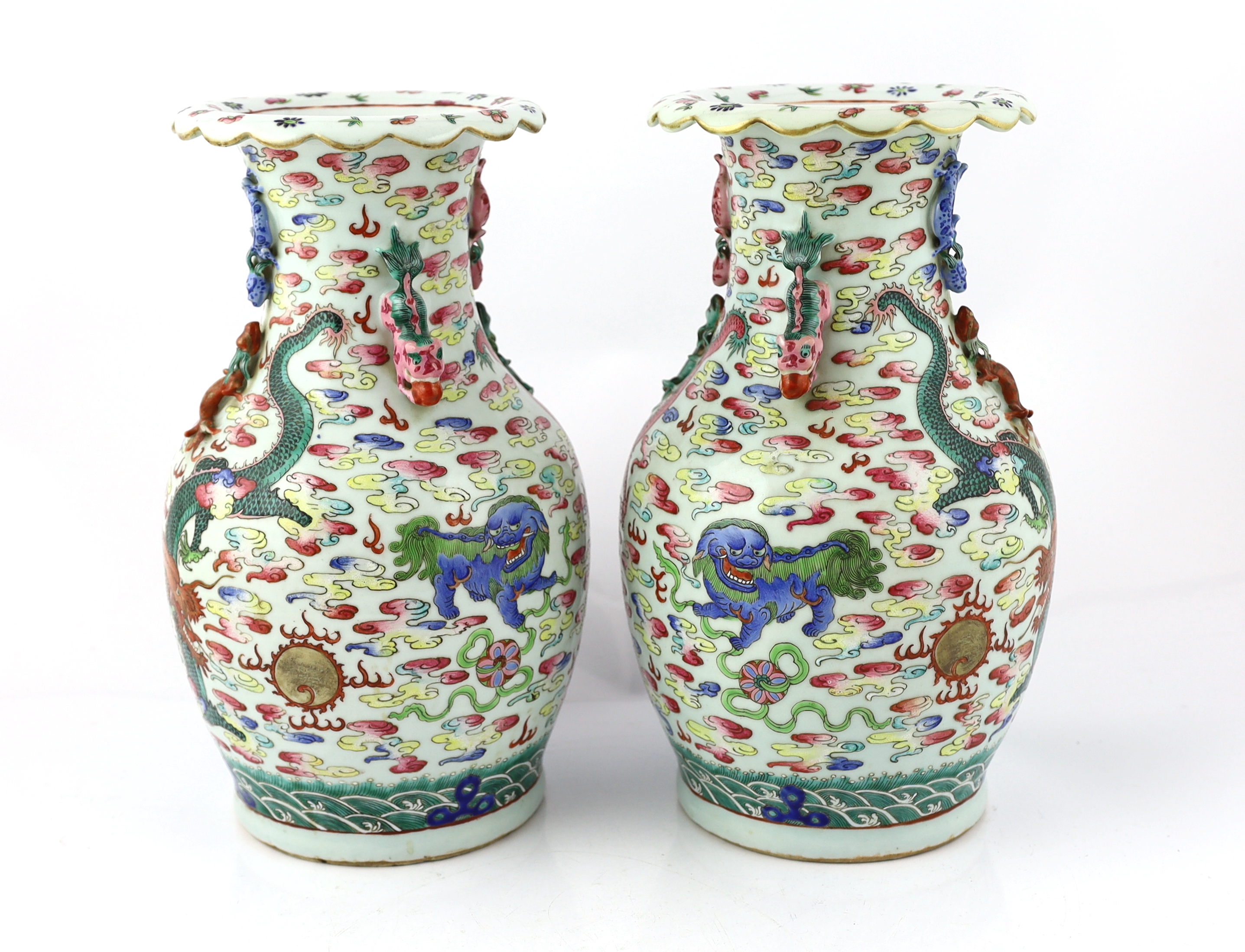 A pair of Chinese enamelled porcelain 'dragon and Buddhist lion' vases, 19th century, body crack to one vase